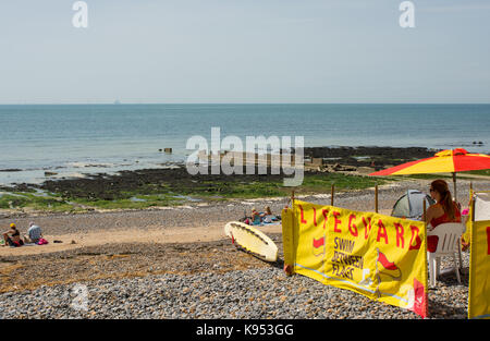 Rettungsschwimmer beobachten, Menschen am Strand bei Ovingdean in der Nähe von Brighton, East Sussex, England Stockfoto