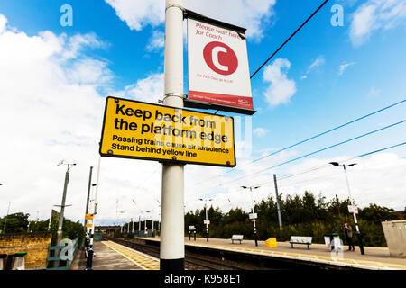 Zug, Bahnhof, Züge verursachen Luftverwirbelungen unterzeichnen, vorbeifahrende Züge Warnschild, hinter der gelben Linie Zeichen stehen, Großbritannien Stockfoto
