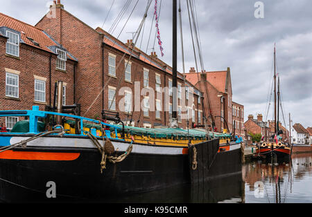 Restaurierte Binnenschiffe entlang der Beck/Kanal neben Stadthäusern an einem schönen Morgen in Beverley, Yorkshire, UK. Stockfoto