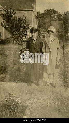 Antike c 1920 Foto, Großmutter und Enkelin für ein Bild im Garten darstellen. Lage unbekannt, wahrscheinlich Neu England. Quelle: original Foto. Stockfoto