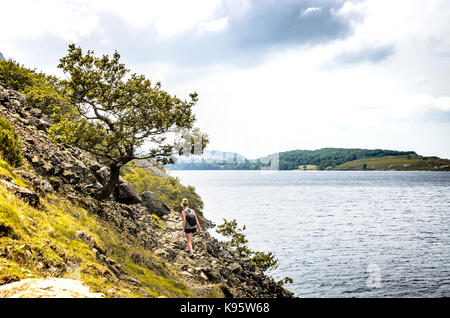 Eine Frau, die zu Fuß an den Ufern der tiefste See in England, Wast Water, in Cumbria Stockfoto