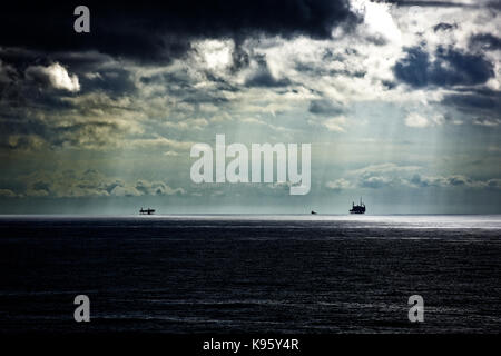 Nordsee Öl Gas Plattformen rigs Stationen gegen drohenden Gewitter wolken Silhouette Stockfoto