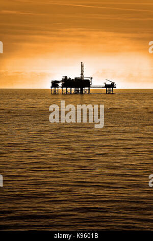 Nordsee Öl Gas Plattformen rigs Stationen gegen warm sky Silhouette Stockfoto
