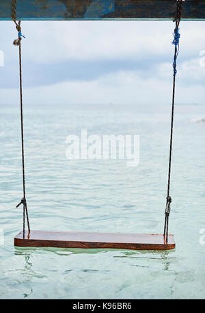 Holz schaukeln auf dem Meer Wasser schwimmend auf Cloud Hintergrund Stockfoto