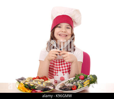 Gerne kleine Mädchen Kochen mit vorbereiteten Forellen für das Mittagessen bereit Stockfoto