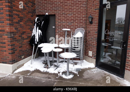 Abgebrochene Chipotle Tische, Stühle und Sonnenschirme Scharen in der Ecke bedeckt mit Schnee warten bis zum nächsten Frühjahr. St. Paul Minnesota MN USA Stockfoto