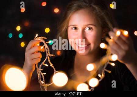 Schöne Mädchen im Teenageralter Holding festliche Weihnachtsbeleuchtung Stockfoto