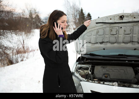 Mädchen auf der Winter ruft das Telefon in der Nähe des Auto Stockfoto