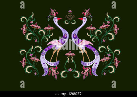 Stickerei stilisierte Vögel unter den Zweig mit lila Blüten und Blätter auf dunkelgrünem Hintergrund Stockfoto
