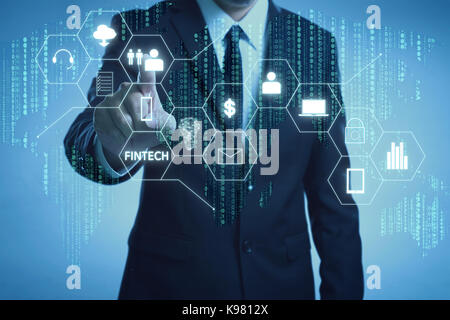 Geschäftsmann mit fintech Symbol und Internet der Dinge mit Matrix Code Hintergrund, Investitionen und finanzielle internet technologie Konzept. Stockfoto