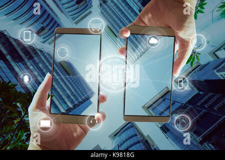 Zwei Unternehmer Hände halten smartphones Zahlungen online shopping und das Symbol für die Netzwerkverbindung auf dem Bildschirm. Stockfoto