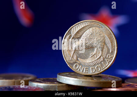 NZ 1 Dollar Münze mit Hintergrund der nationalen Flagge. Stockfoto