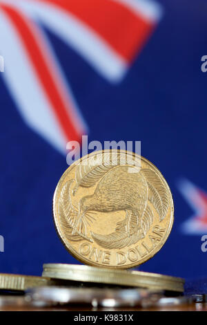 NZ 1 Dollar Münze mit Hintergrund der nationalen Flagge. Stockfoto