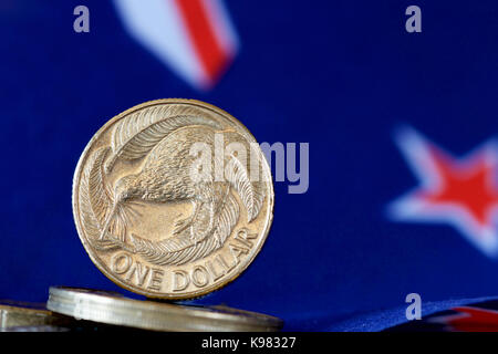 NZ 1 Dollar Münze mit Hintergrund der nationalen Flagge. Stockfoto