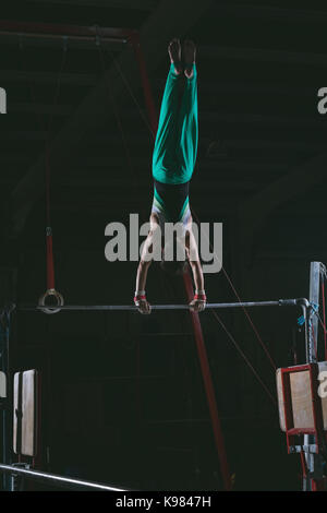 Männliche gymnast Gymnastik üben auf der horizontalen Leiste in der Turnhalle Stockfoto