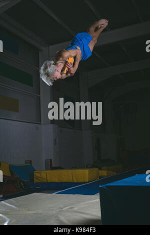 Männliche gymnast üben Gymnastik in der Turnhalle Stockfoto