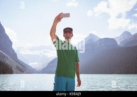 Glückliche Menschen, die in der Nähe von selfie See an einem sonnigen Tag Stockfoto