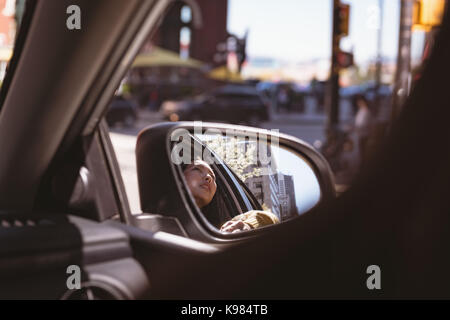 Nahaufnahme der Reflexion der Frau in Außenspiegel Stockfoto
