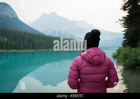 Ansicht der Rückseite stehende Frau in der Nähe des Sees in der Landschaft Stockfoto