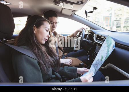 Paar mit Karte im Auto Stockfoto