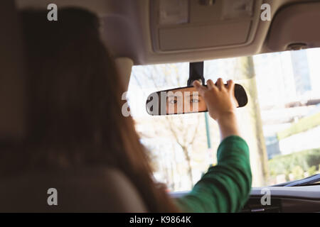Schöne Frau, Blick in den Rückspiegel beim Autofahren Stockfoto