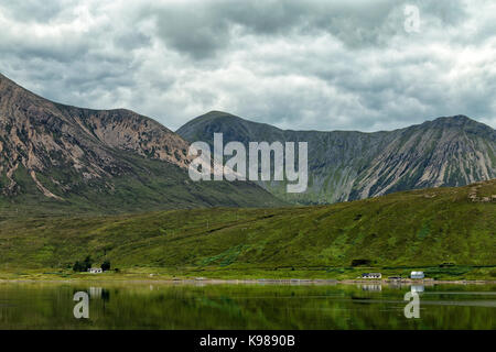 Kleine Häuser über dem hoch aufragenden Glamaig Berg auf der Isle of Skye in Schottland. Stockfoto