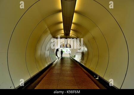 Perspektivische Ansicht entlang einer gekrümmten Fußgängertunnel unter der Hauptstraße im Empress Hotel, Singapur Stockfoto