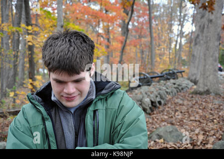 Gettysburg National Military Park, Pennsylvania, USA - 31. Oktober 2016 - jungen Mann zu denken, während am Seminary Ridge mit Kanonen und Blätter im Herbst Stockfoto