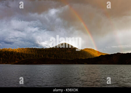 Ein Regenbogen Bogen erhebt sich über das Lavafeld am südlichen Ufer des Butte Lake in den Lassen Volcanic National Park. Stockfoto