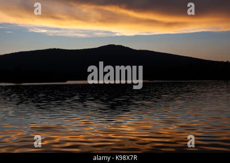 Die Wasser der Butte Lake spiegeln den Sonnenuntergang mit dem silhoutte der Aussicht Peak im Hintergrund. Aussicht Spitze sitzt auf einem Vulkan auf die nor Stockfoto