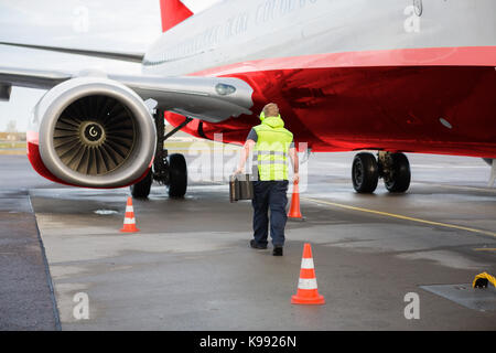 Arbeitnehmer, Leitkegel und Unterlegkeilen Mit dem Flugzeug auf die Start- und Landebahn Stockfoto