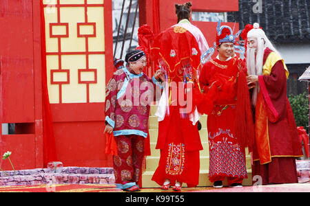 (170922) - SHANGHAI, Sept. 22, 2017 (Xinhua) - Mitarbeiter (1. L und 1. R) als Ehestifter Guide ein Jungvermähltes zu einer Plattform an einer traditionellen chinesischen Hochzeit in der alten Stadt Fengjing in Shanghai, China, Sept. 22, 2017. Insgesamt 21 Jungvermählten nahmen an einer Hochzeit hier. (Xinhua / Fang Zhe) (lfj) Stockfoto