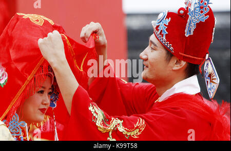 (170922) - SHANGHAI, Sept. 22, 2017 (Xinhua) - Bräutigam Aufzüge rot Bridal Veil für seine Braut an einer traditionellen chinesischen Hochzeit in der alten Stadt Fengjing in Shanghai, China, Sept. 22, 2017. Insgesamt 21 Jungvermählten nahmen an einer Hochzeit hier. (Xinhua / Fang Zhe) (lfj) Stockfoto