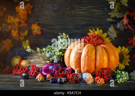 Der hölzerne Tisch mit Gemüse, Kürbis und Blätter im Herbst eingerichtet. Herbst Hintergrund. Schastlivy von Thanksgiving Day. Stockfoto