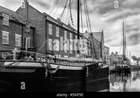 Restaurierte Binnenschiffe entlang der Beck/Kanal neben Stadthäusern an einem schönen Morgen in Beverley, Yorkshire, UK. Stockfoto