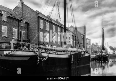 Restaurierte Binnenschiffe entlang der Beck/Kanal neben Stadthäusern an einem schönen Morgen in Beverley, Yorkshire, UK. Stockfoto