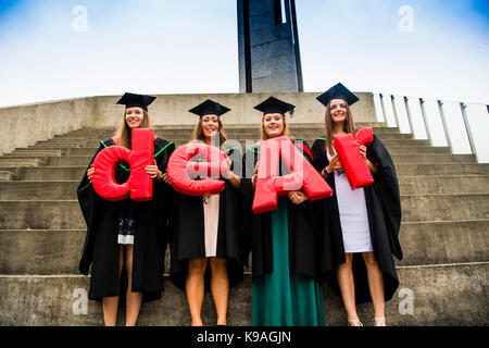 Die Kosten der Hochschulbildung im Vereinigten Königreich: Aberystwyth Studenten tragen traditionelle akademische Kittel und Mörtel Platten-Holding die Buchstaben aber das Wort "Ohr" auf Ihrer Abschlussfeier zu bilden, Juli 2017 Stockfoto