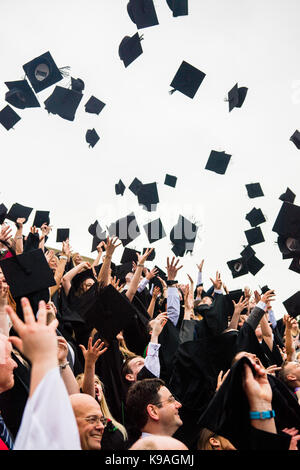 Hochschulbildung im Vereinigten Königreich: Aberystwyth Studenten tragen traditionelle akademische Kleider, ihren Erfolg feiern, indem sie ihre Mörser Bretter werfen in der Luft auf ihre Graduation Day, Juli 2017 Stockfoto