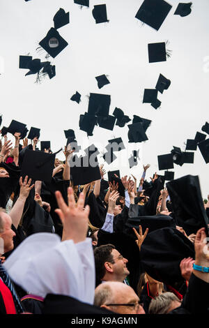 Hochschulbildung im Vereinigten Königreich: Aberystwyth Studenten tragen traditionelle akademische Kleider, ihren Erfolg feiern, indem sie ihre Mörser Bretter werfen in der Luft auf ihre Graduation Day, Juli 2017 Stockfoto