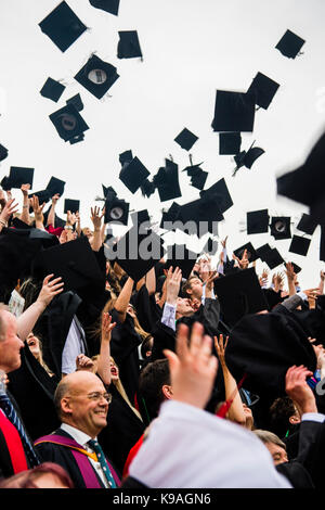 Hochschulbildung im Vereinigten Königreich: Aberystwyth Studenten tragen traditionelle akademische Kleider, ihren Erfolg feiern, indem sie ihre Mörser Bretter werfen in der Luft auf ihre Graduation Day, Juli 2017 Stockfoto