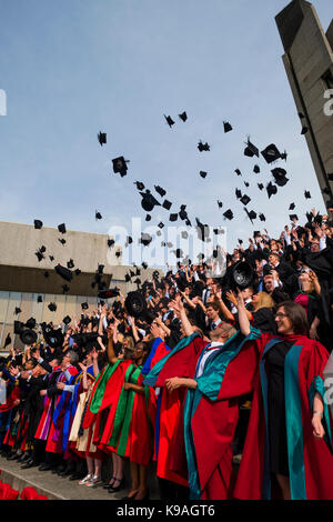 Hochschulbildung im Vereinigten Königreich: Aberystwyth Studenten tragen traditionelle akademische Kleider, ihren Erfolg feiern, indem sie ihre Mörser Bretter werfen in der Luft auf ihre Graduation Day, Juli 2017 Stockfoto