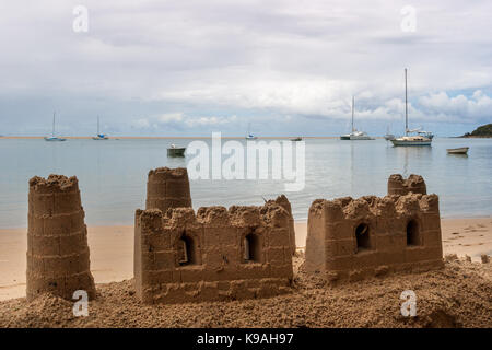 Sandburgen am Strand und Yachten in der Bucht vor Anker - ein perfektes Urlaubsziel. Stockfoto