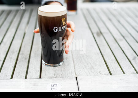 Ein pint Glas Guinness zu ergriffen werden. Stockfoto