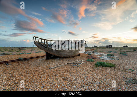 Eine alte verlassene Fischerboot unter einem dramatischen Himmel am Strand von Dungeness an der Küste von Kent Stockfoto