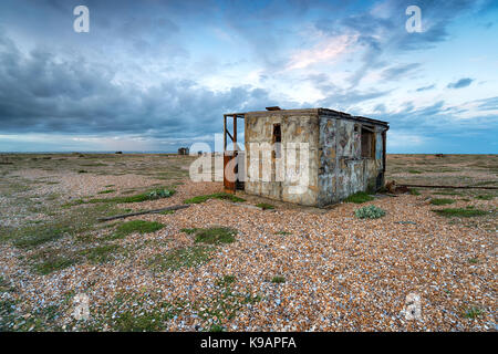 Verlassenen Fischerhütten unter einem dramatischen Himmel in Dungeness an der Küste von Kent Stockfoto