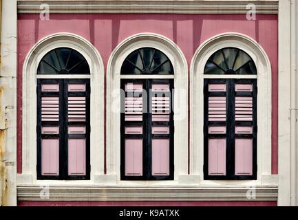 Traditionelle Singapur shop Haus außen mit rosa Fassade, Bogenfenster und Rosa hölzerne Lamellenfensterläden im historischen Duxton Bezirk. Stockfoto