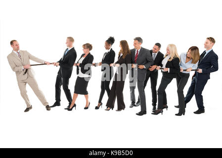 Männliche leader ziehen Business Team beim Spielen Tauziehen gegen den weißen Hintergrund Stockfoto