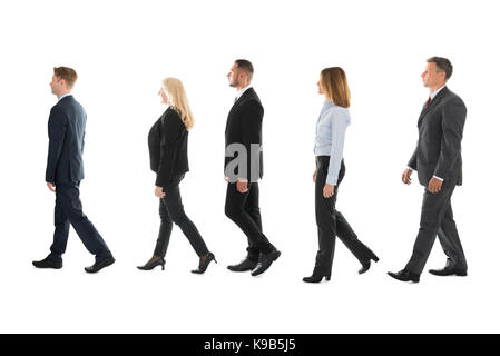 Volle Länge Seite Blick auf die Menschen zu Fuß gegen den weißen Hintergrund Stockfoto