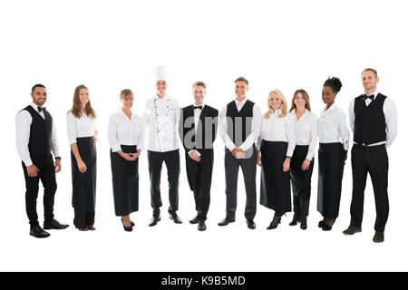 Volle Länge Portrait von zuversichtlich, das Personal im Restaurant stehen in der Zeile vor weißem Hintergrund Stockfoto