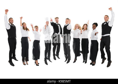 Volle Länge Portrait von glücklichen Angestellten im Restaurant feiert Erfolg gegen weißen Hintergrund Stockfoto